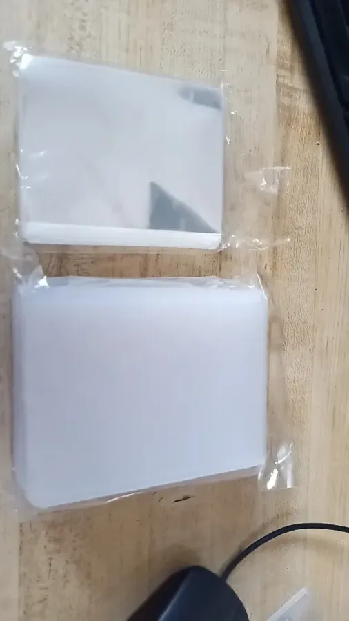 Buyer photo of a rigid toploader and sleeve stack on a desk