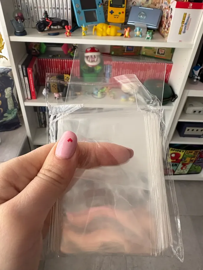 Buyer photo holding a pack of clear penny sleeves in front of a shelf